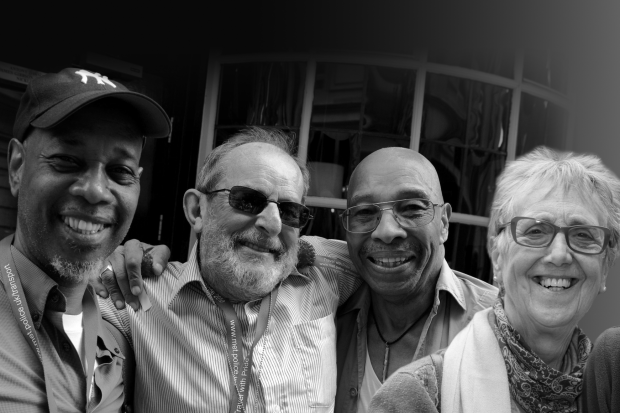 Black and white photo of four older LGBT men and women smiling