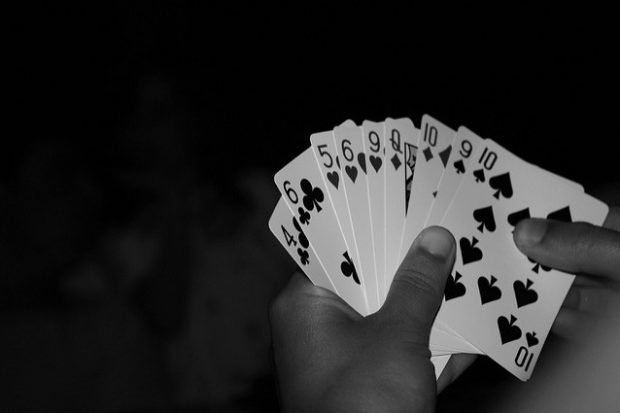 A hand of playing cards fanned out against a black background