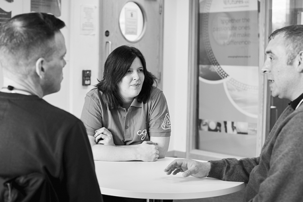 A Change Grow Live colleague in conversation with two service users in a meeting room