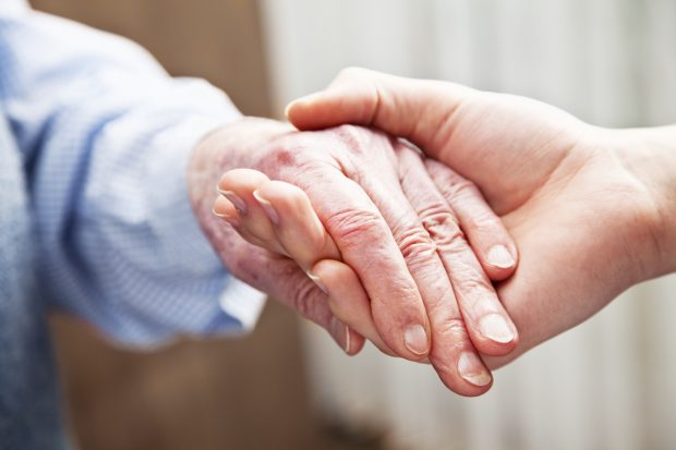 Carer holding an elderly person's hand